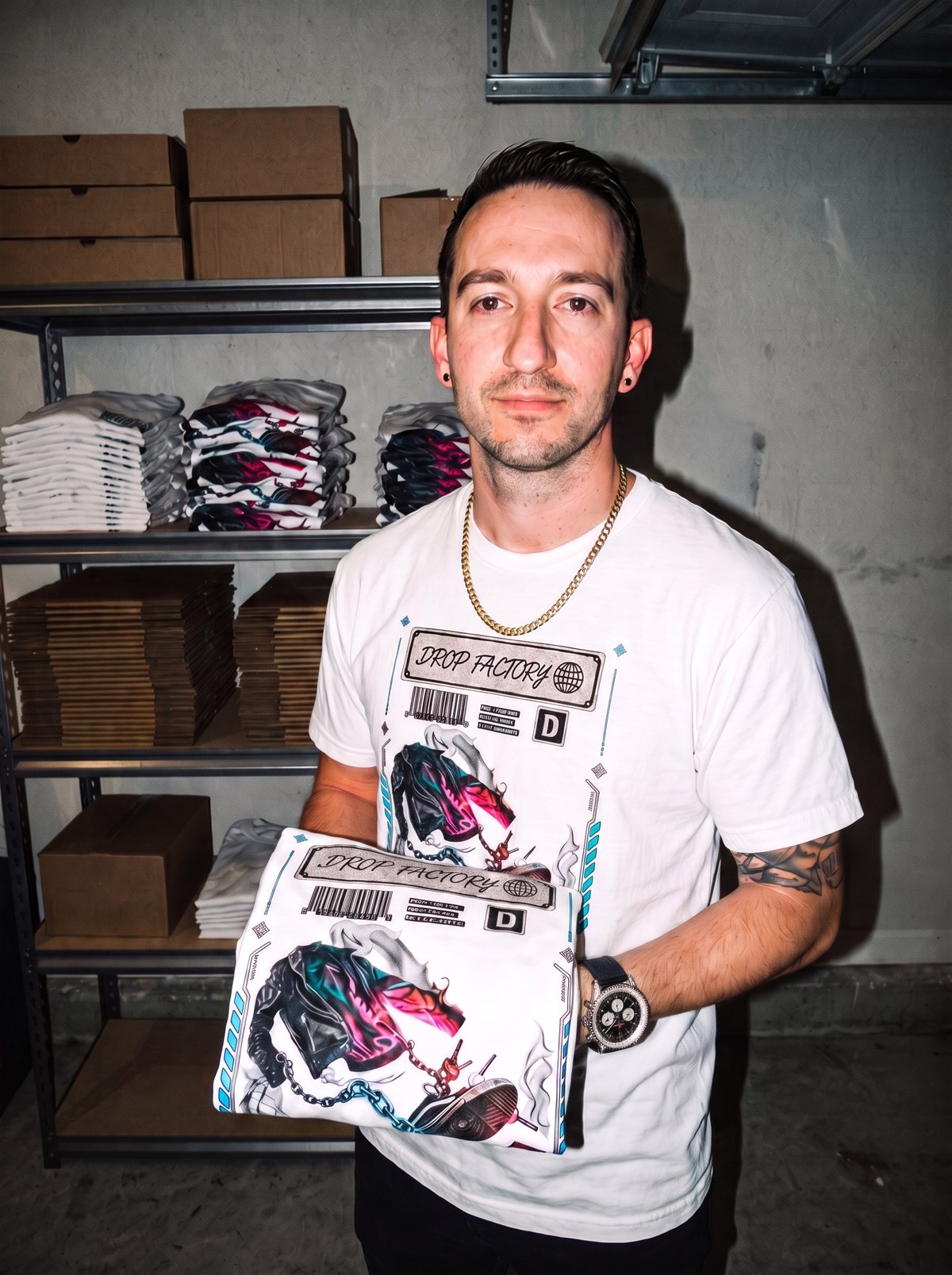 Rich, founder of Drop Factory, holding a folded Drop Factory tee